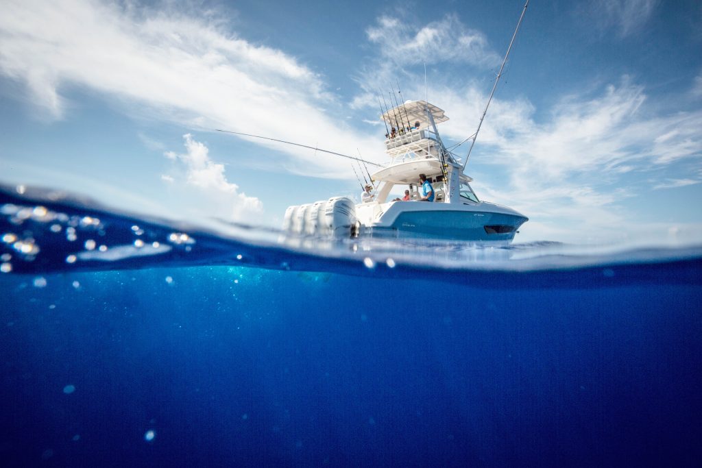 A fishing boat in the ocean off the coast of the Bahamas, against a backdrop of a clear blue sky.