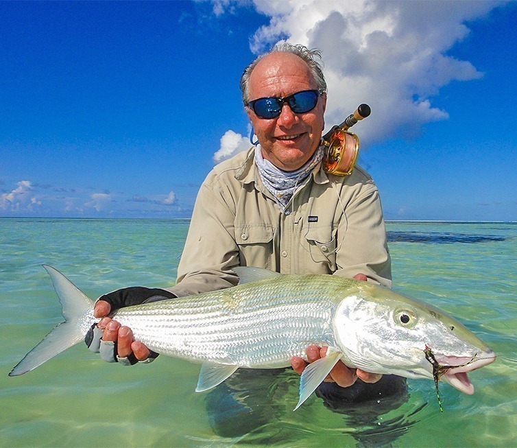 A man holding up a fish during a Bahamas Travel adventure.