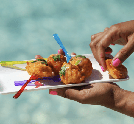 A person enjoying a plate of food during their Bahamas all-inclusive vacation.