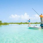 Two men enjoying a fishing excursion in the clear blue waters of the Bahamas.