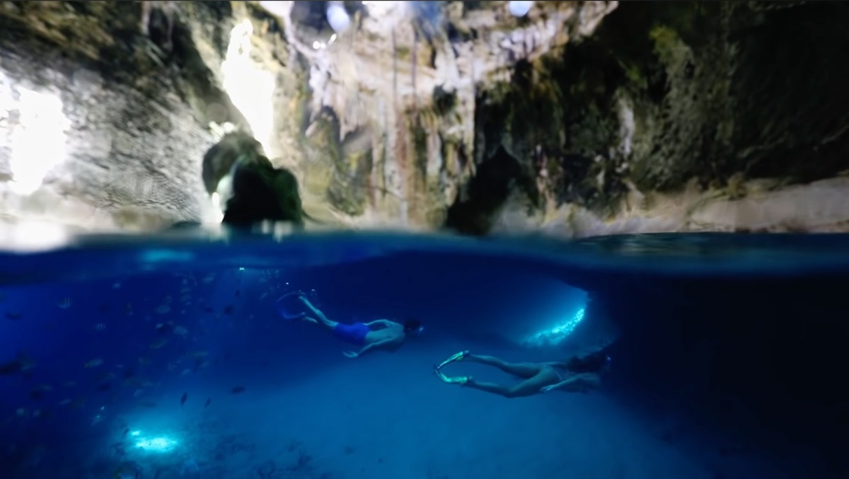 Two people are swimming in a cave in Mexico during their Bahamas Travel.